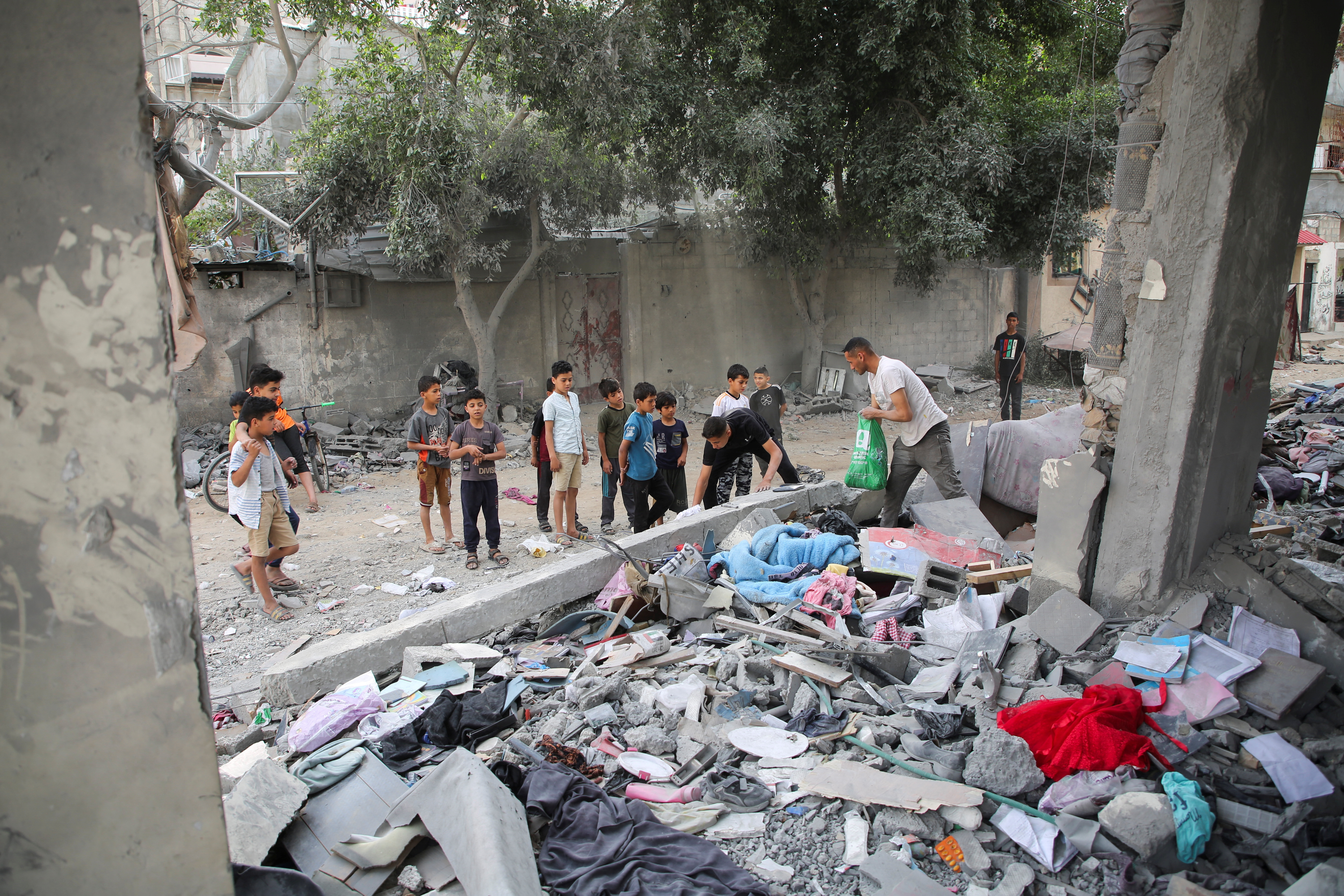 Palestinians inspect the site of an Israeli strike on a house in Rafah