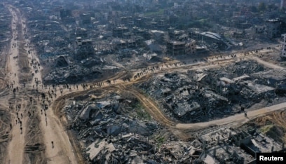 A drone view shows displaced Palestinians walking past the rubble as they attempt to return to their homes, amid a ceasefire between Israel and Hamas, in the northern Gaza Strip, Jan. 19, 2025.