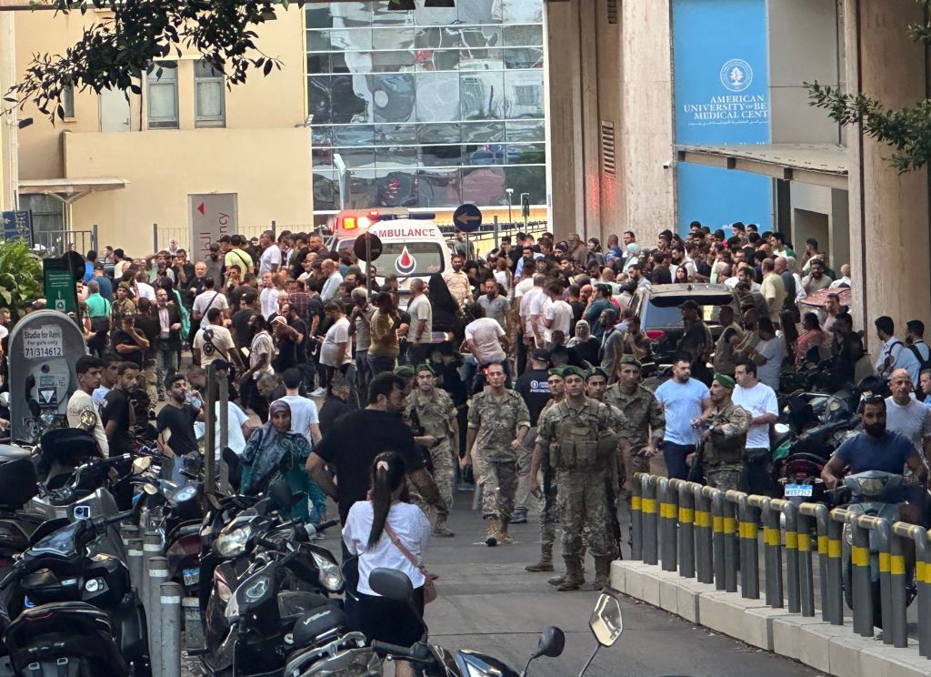 Lebanese soldiers and Hezbollah members gather outside a hospital where injured people were being transported following the explosions.