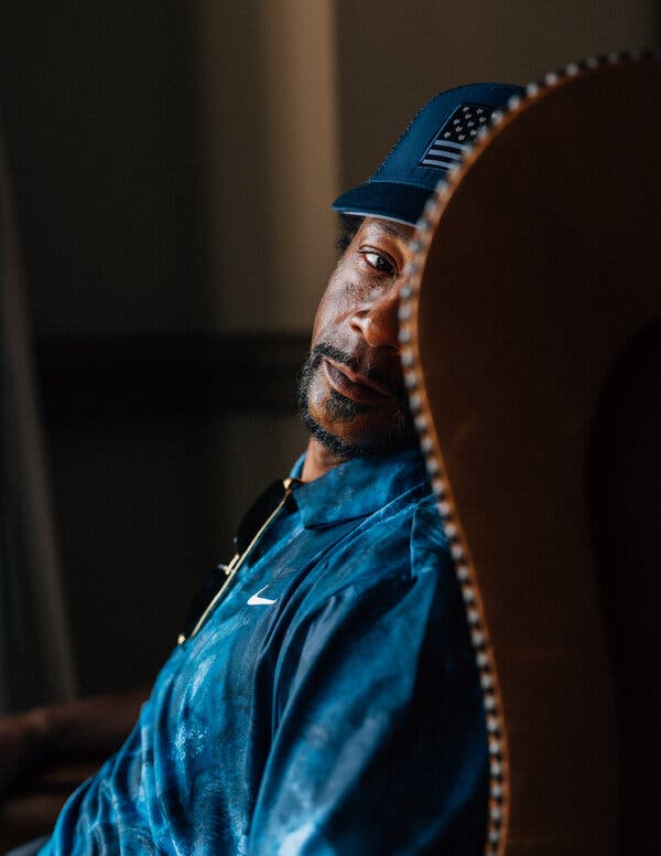 A contemplative Williams is seen in profile as he sits in a chair that hides part of his face.