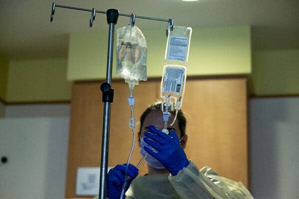 A nurse adjusts a tube line running from the bag containing the treated cells to be infused into Kendric's system.