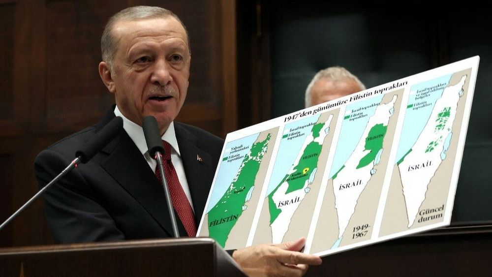 Turkish President Recep Tayyip Erdogan holds a map showing the evolution of lands of Israel and Palestine at his party's group meeting in the Turkish Grand National Assembly in Ankara on October 11, 2023.