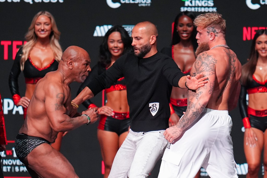 Promoter Nakisa Bidarian, center, co-founder of Most Valuable Promotions, steps in the way of Mike Tyson, left, after Tyson slapped Jake Paul during a weigh-in