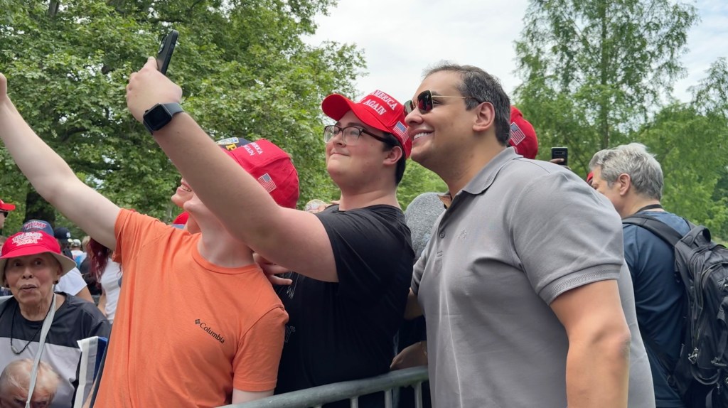 Former Rep. George Santos taking selfies with members of the crowd at the rally.