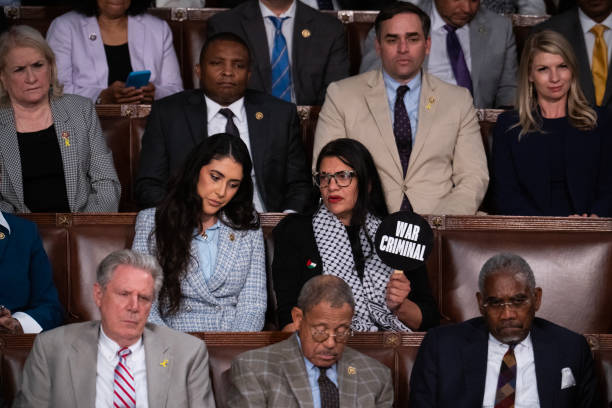 united-states-rep-rashida-tlaib-d-mich-holds-a-war-criminal-sign-as-rep-anna-paulina-luna-r.jpg