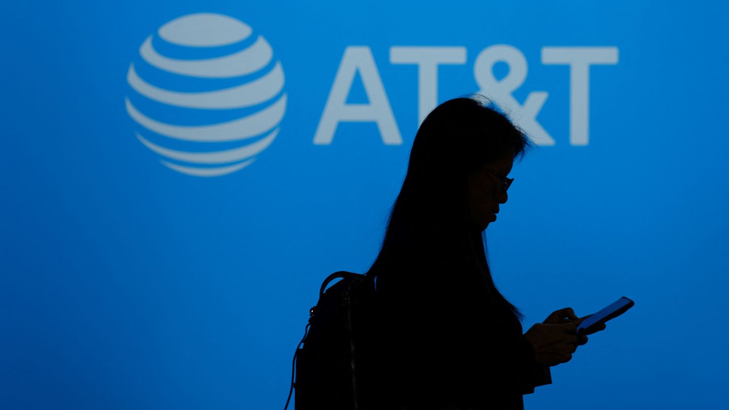 A visitor walks past an AT&T logo.