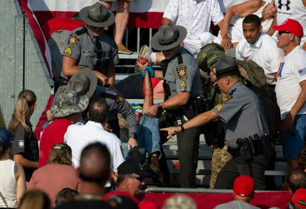 a-person-is-removed-by-state-police-from-the-stands-after-guns-were-fired-at-republican.jpg