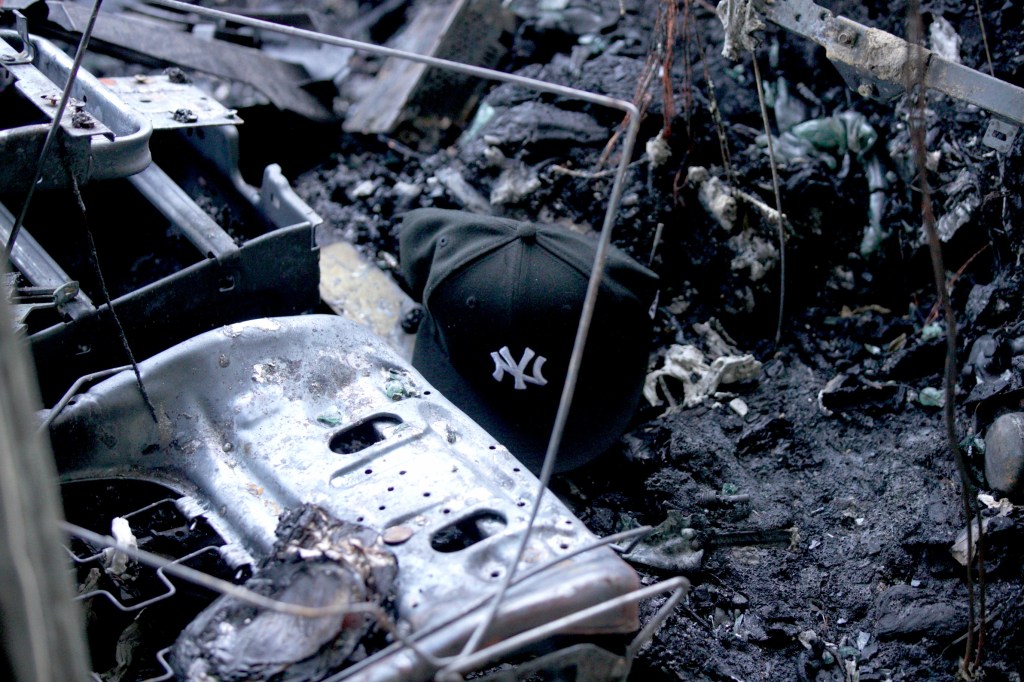 A New York Yankees baseball hat is left behind among the wreckage of the deadly Henry Hudson Parkway crash.