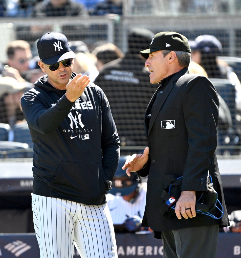 Aaron Boone (17) argues a call by umpire Angel Hernandez (5) on Yankees second base Gleyber Torres 