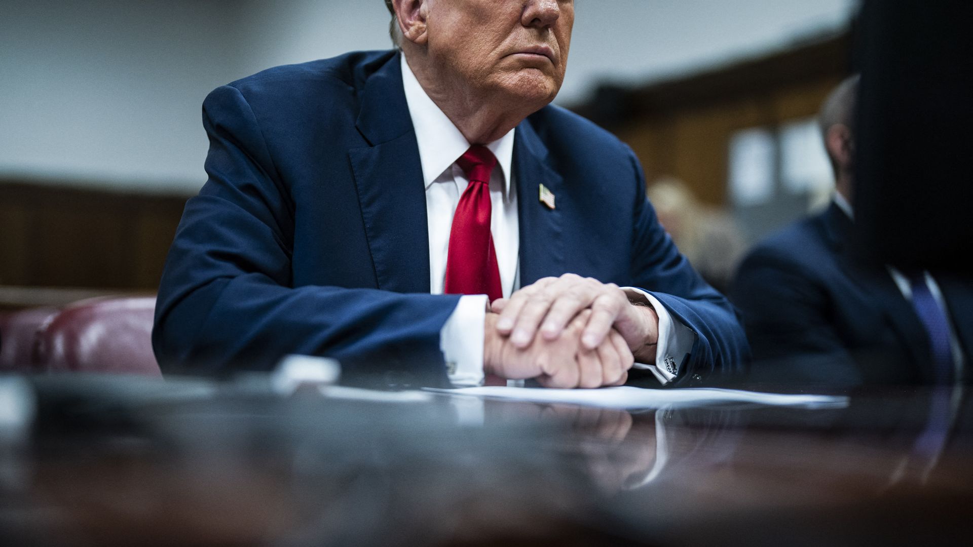 A closeup of Donald Trump, seated at a table