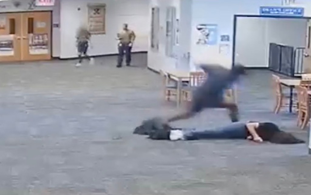 Screen grab of the student punching the teacher on the floor. 