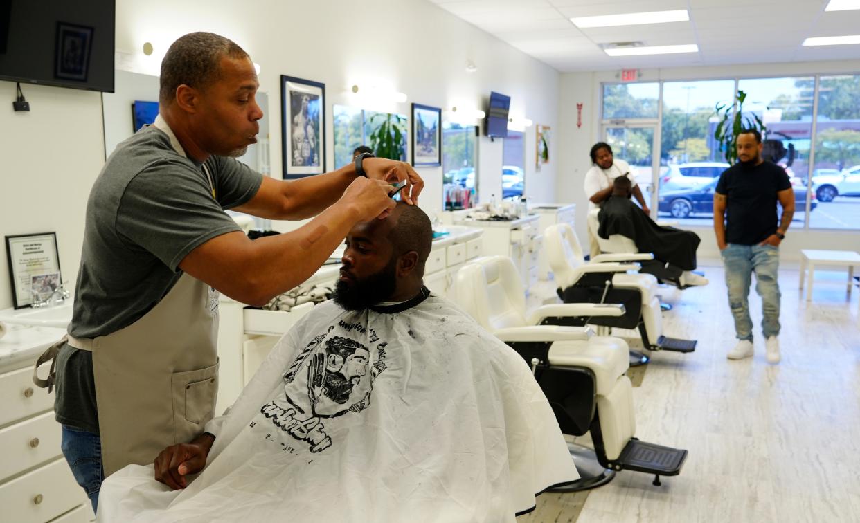 Co-owner of Champion City Cuts, Rufus Humphrey, left, and Joe Ruck, right, talk about the influx of Haitians into the community, Tuesday, Sept. 10, 2024. The business is in the strip mall on the west side of the city, they say is known as “Little Haiti”.