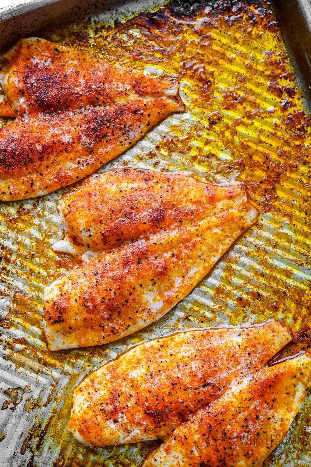 Baked flounder on a baking sheet.