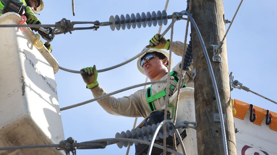 linemen working on an electric pole