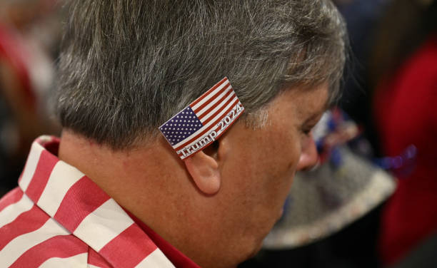 an-ttendee-wearing-a-usa-flag-patch-on-his-ear-prays-during-a-sermon-by-president-and-ceo-of.jpg