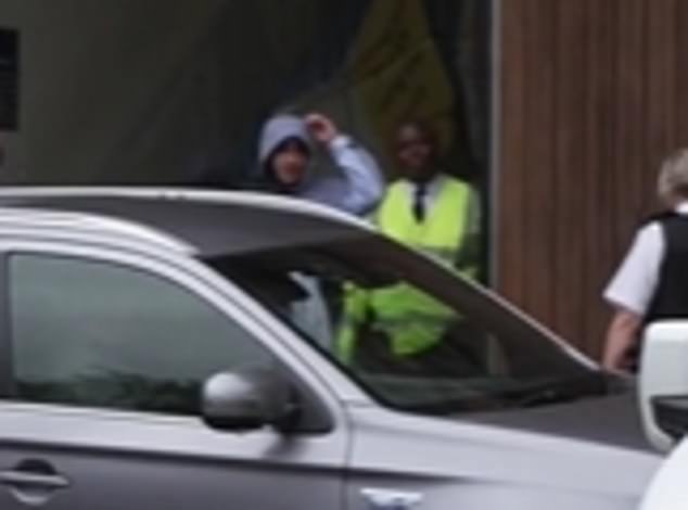 He looks around in astonishment as he notices police officers are waiting for him