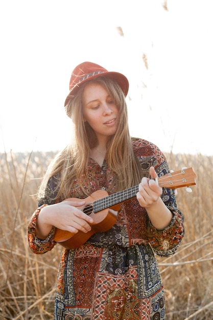 bohemian-woman-playing-ukulele-field_23-2148522786.jpg