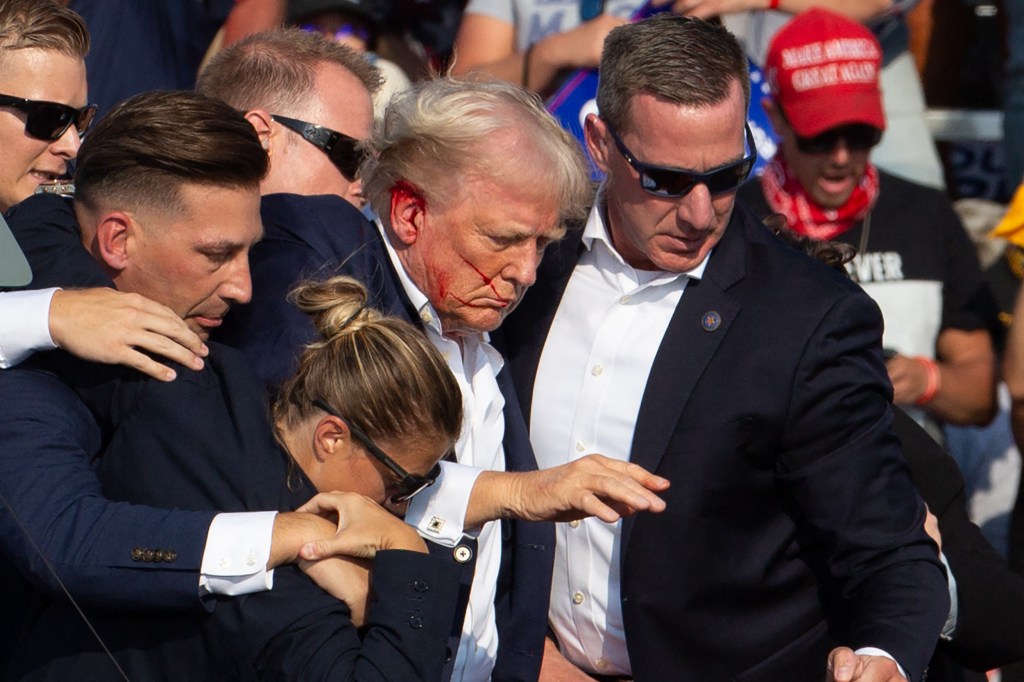 Trump is seen with blood on his face surrounded by secret service agents as he is taken off the stage at a campaign event at Butler Farm Show Inc. in Butler, Pennsylvania, on July 13, 2024. 