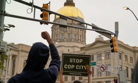 people hold signs and raise fists outside state capitol