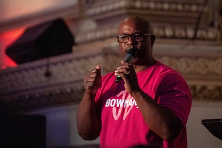 a man in a red shirt speaks into a microphone